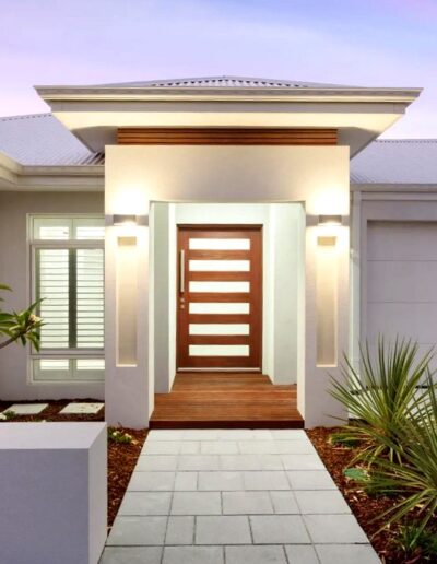 Luxury custom home in Perth featuring contemporary facade with timber door, feature lighting, and native landscaping by premier Perth home builder